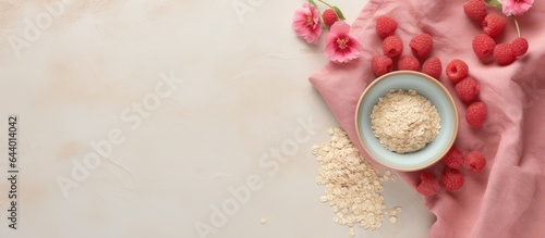 In a textile covered bowl there are oat flakes and raspberry isolated pastel background Copy space photo