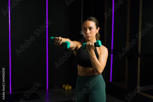 Strong fit woman doing cross training with dumbbell weights