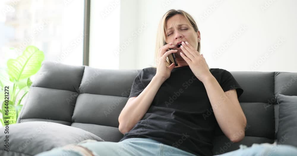 Young bored businesswoman yawning and talking on phone indoors. Portrait of woman of anxiety and boredom Young bored businesswoman yawning and talking on phone indoors. Portrait of woman of anxiety and boredom