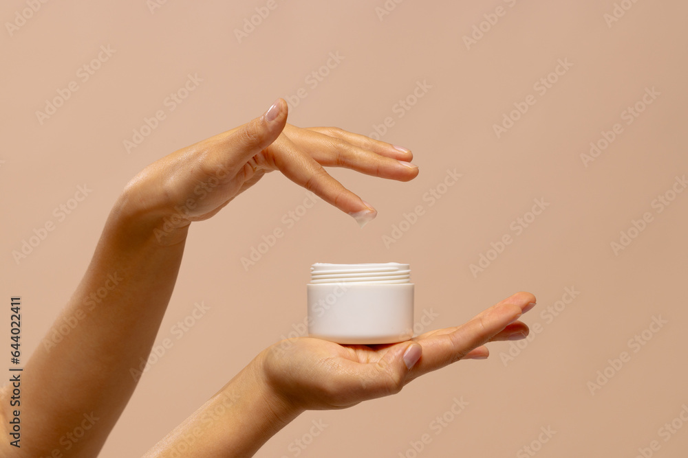 Hands of asian woman using jar of beauty cream with copy space Hands of asian woman using jar of beauty cream with copy space