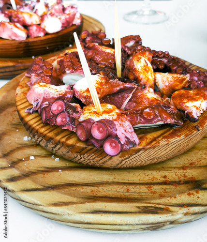 Delicious wooden plates of galician style cooked octopus with paprika and olive oil. Pulpo a la gallega photo