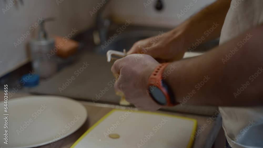 Hands close-up a man peels potatoes with knife in kitchen at home. Cooking, healthy eating. Process cleaning vegetables. Healthy meal. Peeling fresh yellow potato kitchen peeler. Food preparation. Hands close-up a man peels potatoes with knife in kitchen at home. Cooking, healthy eating. Process cleaning vegetables. Healthy meal. Peeling fresh yellow potato kitchen peeler. Food preparation.