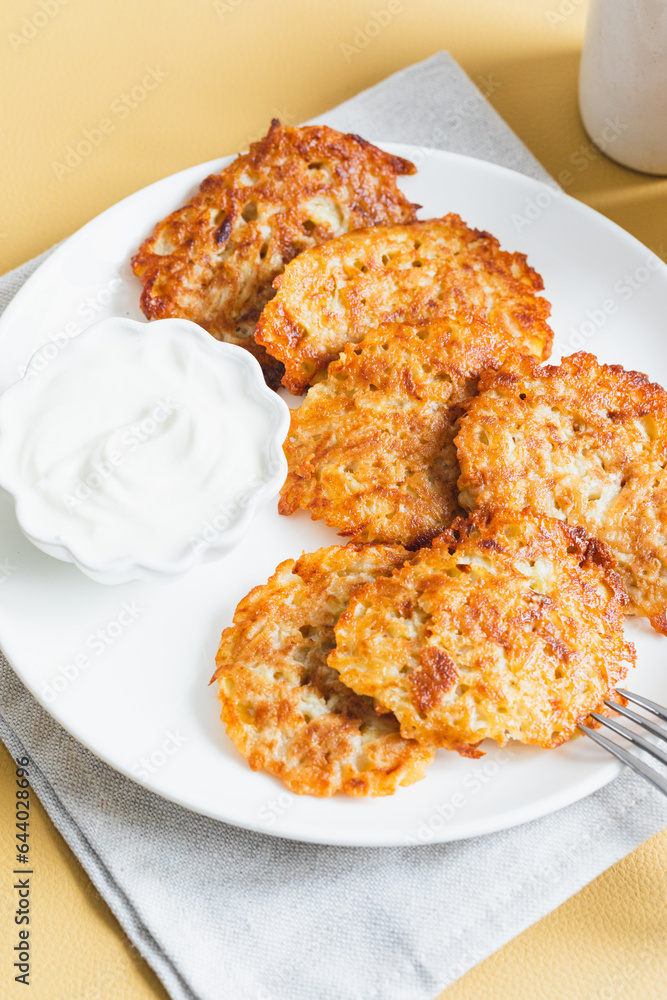Potato pancakes or latkes or draniki with sour cream. Ukrainian food. A grated potato dish of Deruny or Draniki Potato pancakes or latkes or draniki with sour cream. Ukrainian food. A grated potato dish of Deruny or Draniki
