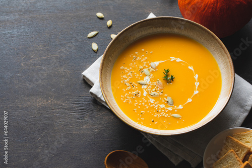 Roasted pumpkin and carrot soup with pumpkin  and hemp seeds. Pumpkin traditional soup with creamy silky texture.