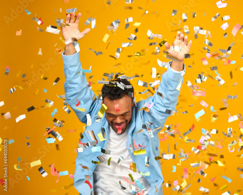 Studio Shot Of Man With Down Syndrome Celebrating Big Win Showered In Tinsel Confetti