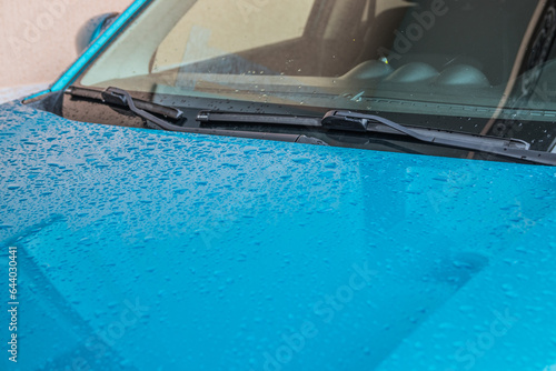 Raindrops on the car. Car element with raindrops close-up. Doors, mirror and glass of a blue car in raindrops. Big raindrops on the car very close © decorator