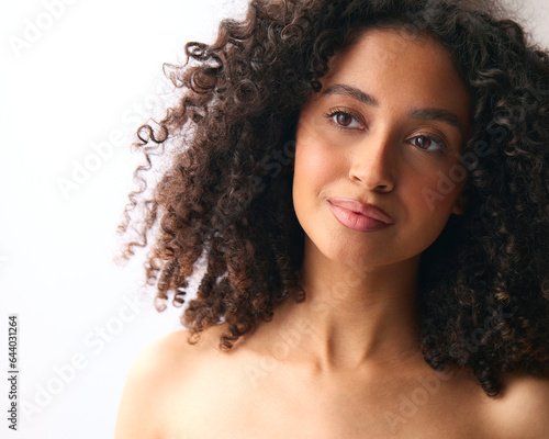 Studio Portrait Of Smiling Natural Woman With Bare Shoulders Standing Against Neutral Background
