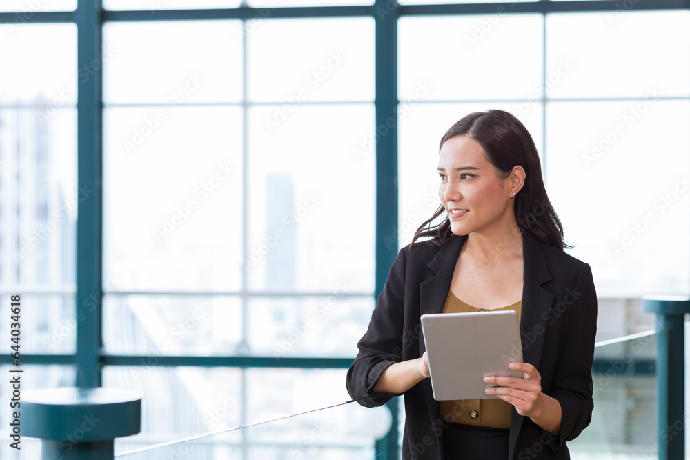 Businesswoman using tablet computer standing near workplace, touching. Young female office worker using apps at her tablet. Businesswoman using tablet computer standing near workplace, touching. Young female office worker using apps at her tablet.