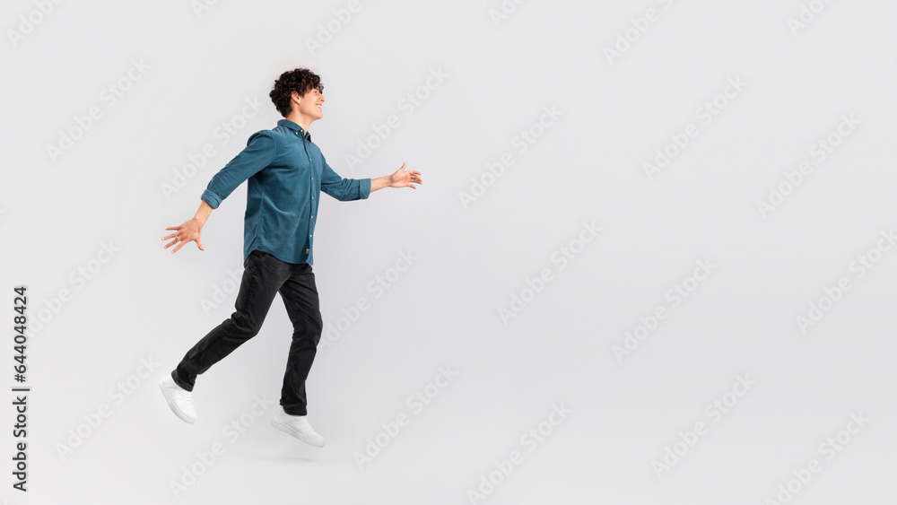 Happy positive young man walking towards copy space, white background Happy positive young man walking towards copy space, white background