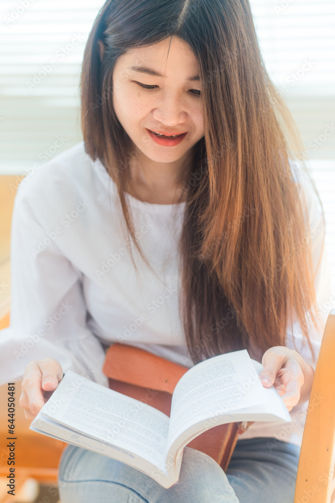 Happy asian student young woman thinking with book in library Happy asian student young woman thinking with book in library