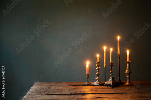 Tableau sur toile burning candles in vintage candlesticks on dark background