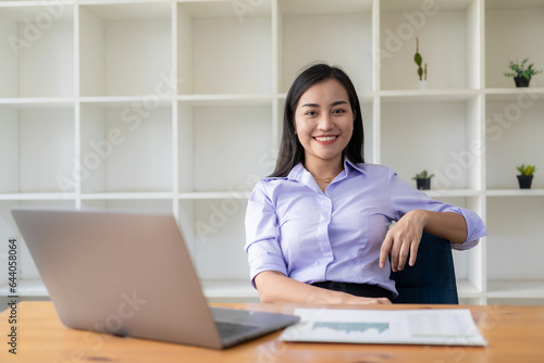Asian woman working with financial documents and laptop in office, financial accounting concept