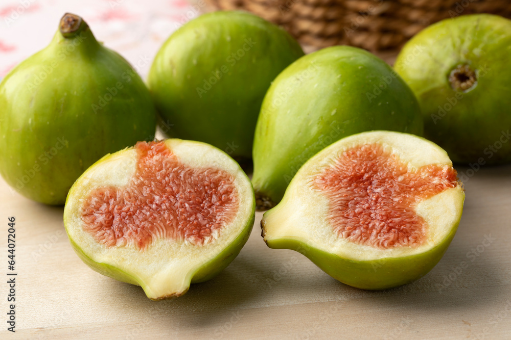 Heap of fresh whole and halved green figs close up as dessert