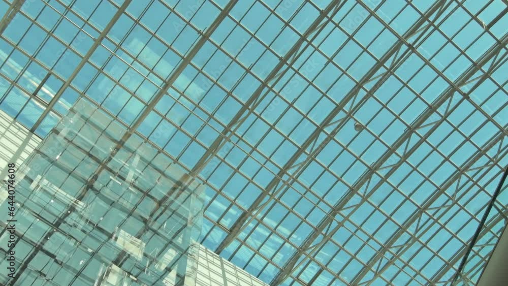 beautiful glass ceiling and elevator of big shopping mall with cloud sky through beautiful glass ceiling and elevator of big shopping mall with cloud sky through