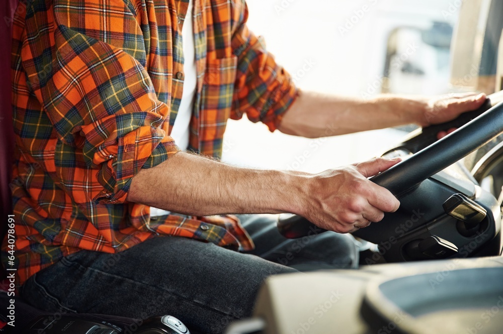 Close up view, sitting inside. Young truck driver in casual clothes