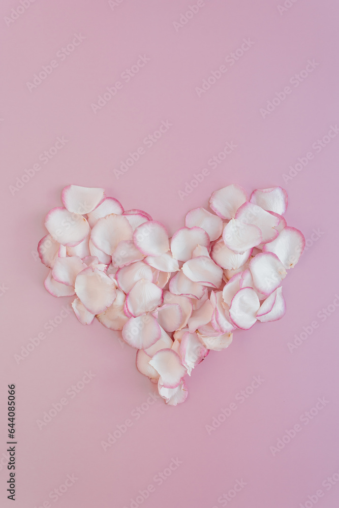 Valentine's Day composition. Heart made of rose flower petals on pale pastel pink background. Flat lay, top view love concept