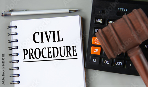 CIVIL PROCEDURE - words in a white notebook on the background of a calculator and a judge's gavel