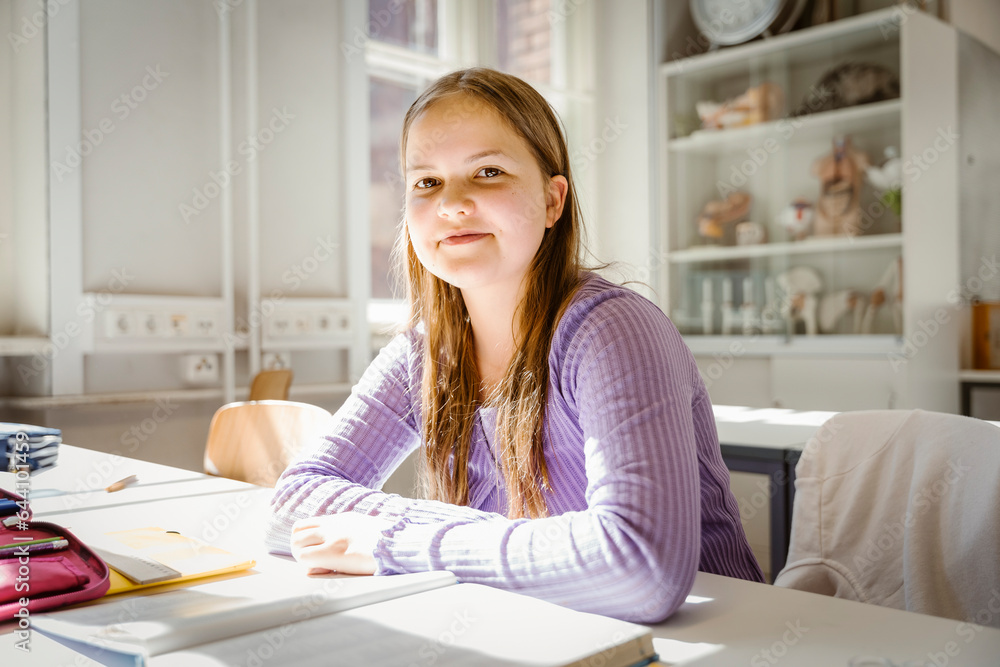Portrait of smiling girl sitting at desk in classroom Portrait of smiling girl sitting at desk in classroom