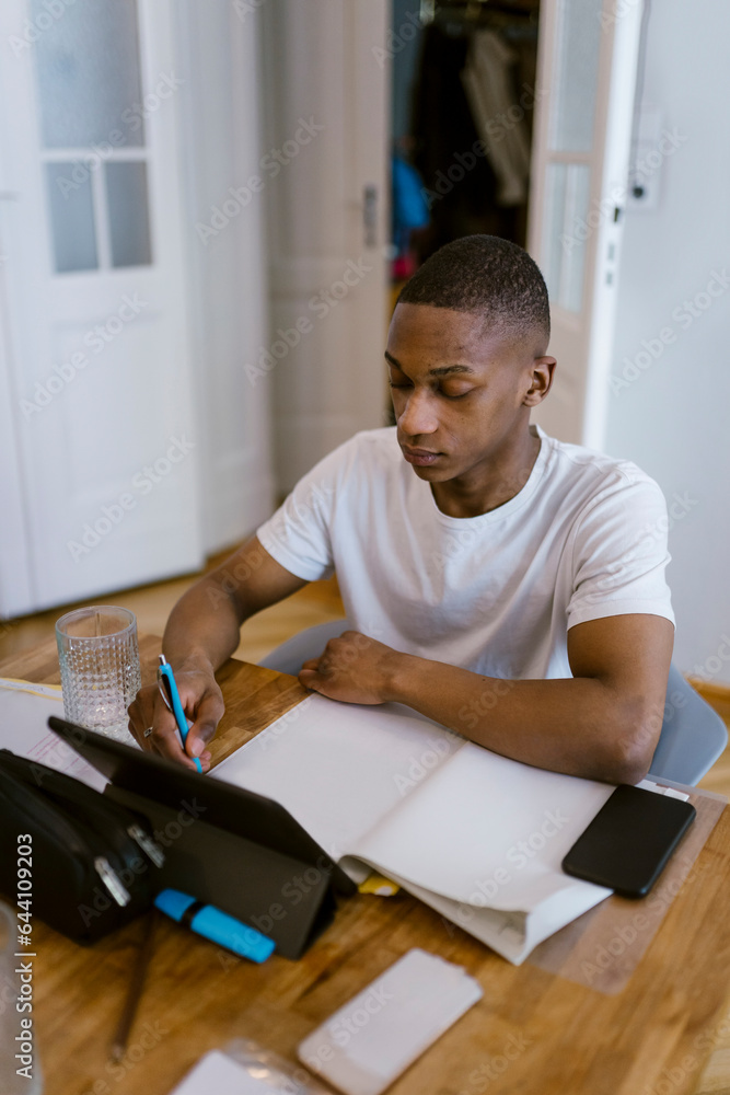 Young man learning with digital tablet at home Young man learning with digital tablet at home
