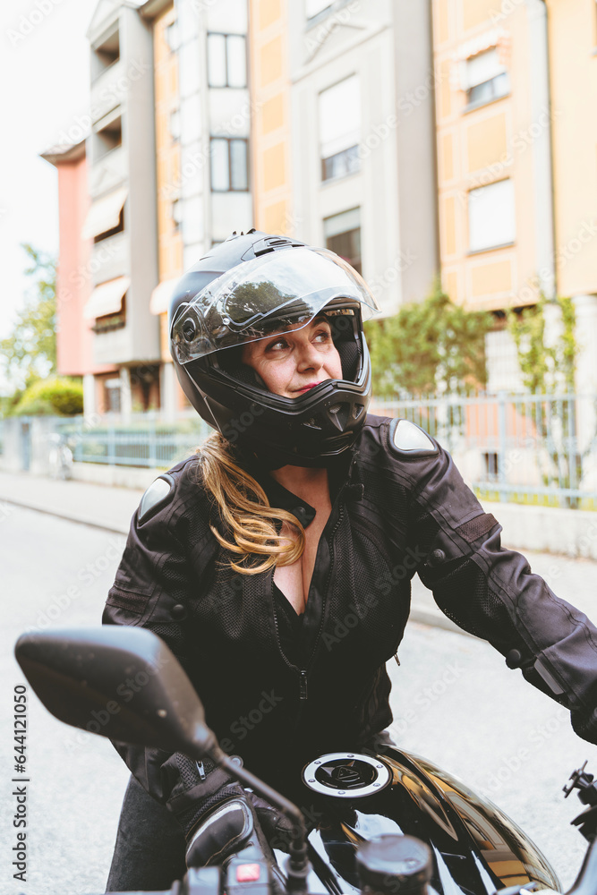 middle aged woman in motorbiker clothing riding a modern motorcycle outdoors middle aged woman in motorbiker clothing riding a modern motorcycle outdoors