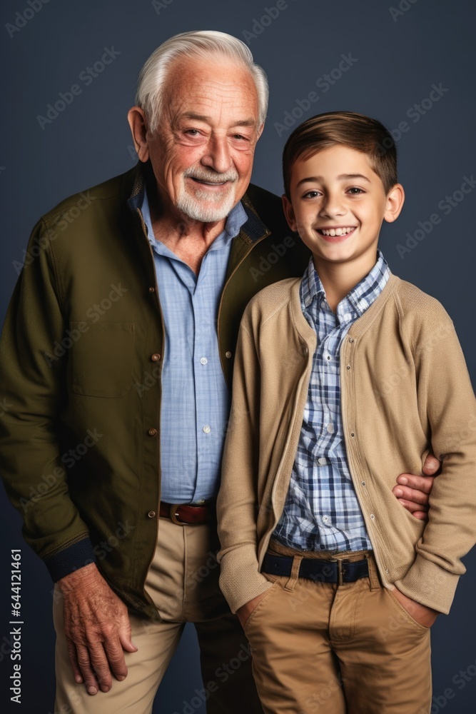 cropped shot of a man and his grandson posing together in studio cropped shot of a man and his grandson posing together in studio