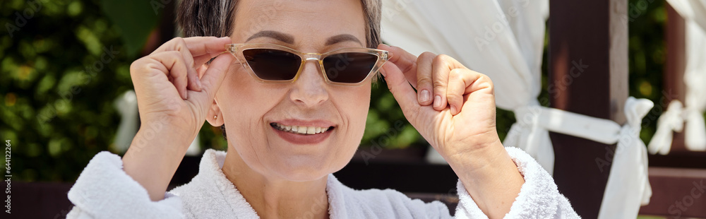 happy middle aged woman wearing sunglasses and looking at camera during wellness retreat, banner