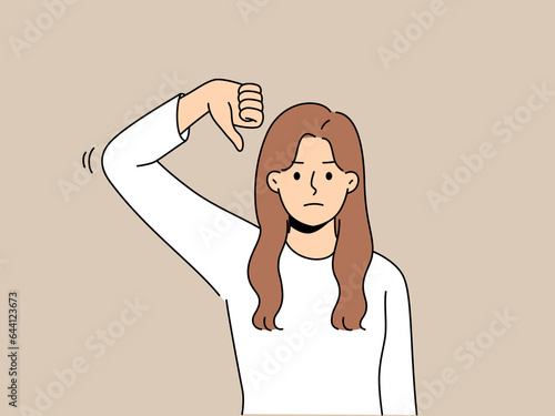 Frustrated woman gives thumbs down as sign of disbelief or rejection of proposed plans. Disgruntled girl makes thumbs down gesture, urging not to spread fake news and misinformation.