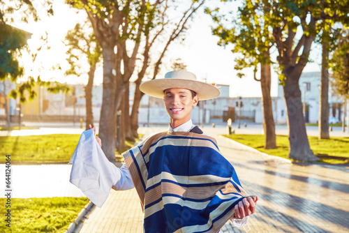 retrato joven con traje de huaso sosteniendo un pañuelo en el plaza de la ciudad