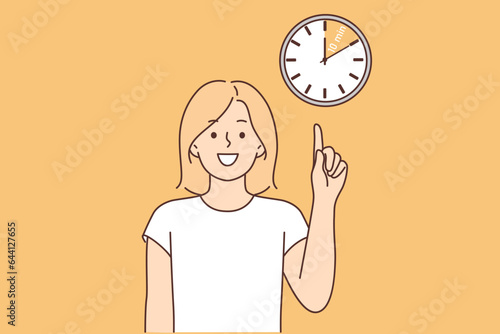 Woman points finger at clock, reminding of break and desire to have time to rest in 10 minutes