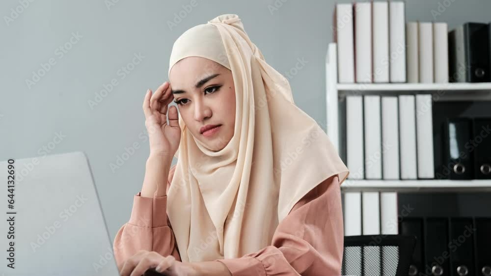 Exhausted young Arab woman in hijab tired after working on laptop, having headache at home. Young middle Eastern female in headscarf overworking on freelance job Exhausted young Arab woman in hijab tired after working on laptop, having headache at home. Young middle Eastern female in headscarf overworking on freelance job
