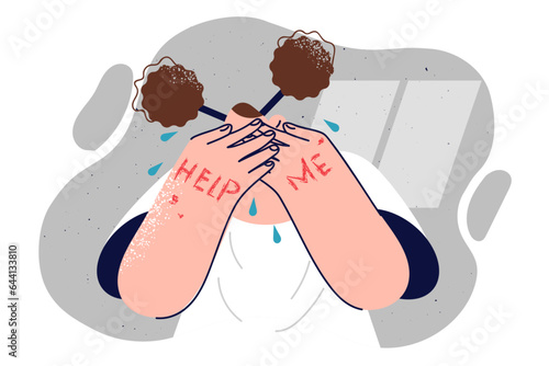 Teenage girl is crying, covering eyes with hands with text help me, for concept of family violence 