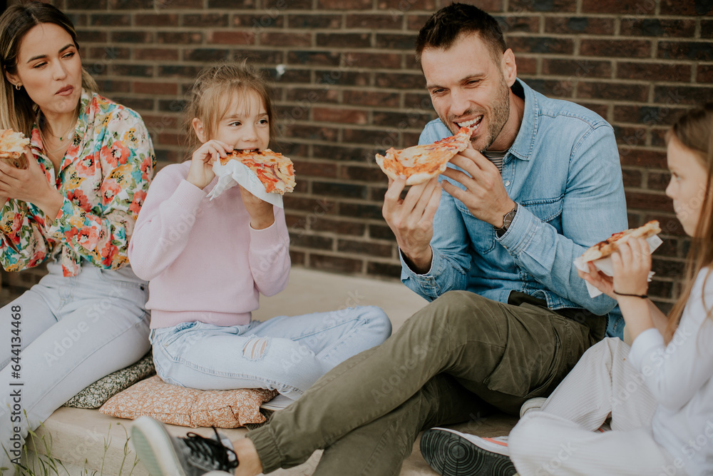 Group of young people and kids eating pizza in the house backyard Group of young people and kids eating pizza in the house backyard