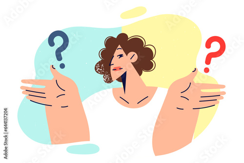 Woman making difficult choice from two options spreads hands, standing near question marks