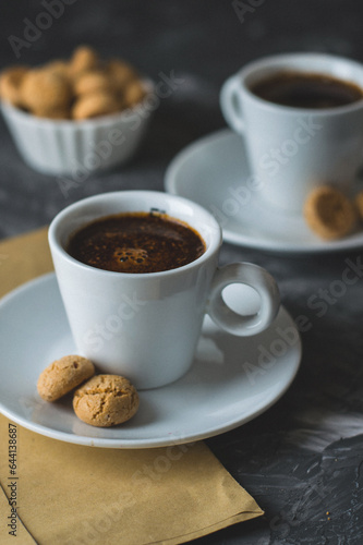 Two cups of espersso coffee and cookies on a dark background