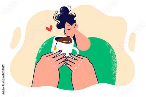 Man holds mug of tea and drinks hot refreshing drink to keep warm on cold winter evening