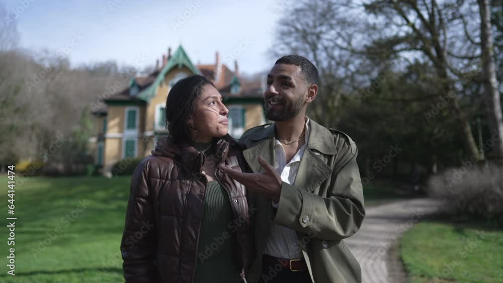 Joyful couple walking at park hugging each other. Loving romantic boyfriend and girlfriend strolling together outside Joyful couple walking at park hugging each other. Loving romantic boyfriend and girlfriend strolling together outside