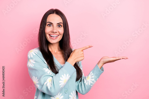 Photo of overjoyed impressed woman dressed blue cardigan directing at palm show proposition empty space isolated on pink color background