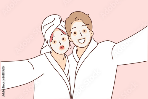 Man and woman with cosmetic masks on faces, dressed in bathrobes to perform SPA treatments