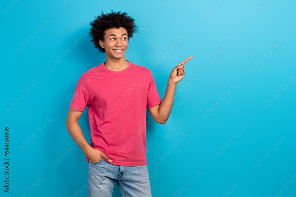 Photo of funky positive man wear trendy clothes looking interesting offer empty space isolated on blue color background Photo of funky positive man wear trendy clothes looking interesting offer empty space isolated on blue color background