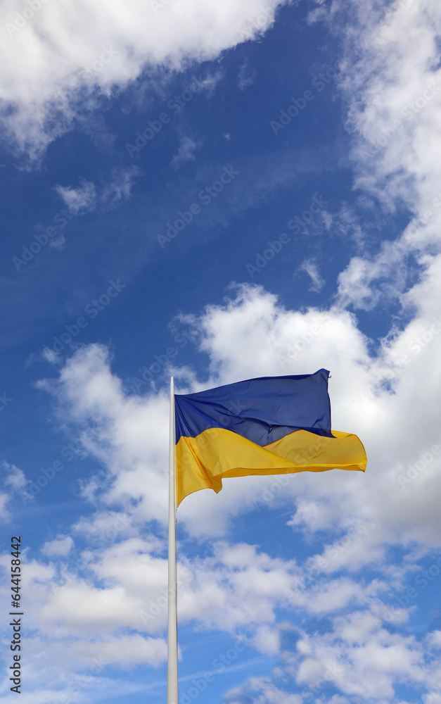 flag of Ukraine with colors blue above yellow below waving in the sky and clouds with space above for your own text lettering flag of Ukraine with colors blue above yellow below waving in the sky and clouds with space above for your own text lettering