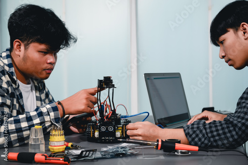Engineer Asian Students Assembling Robotics Kits. Learning Mechanical Control by Computer, Robotics combines computer, electrical, mechanical, and sensing. Empowering Engineers and Development.