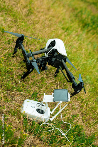  White drone with dron remote controller on the grass. 