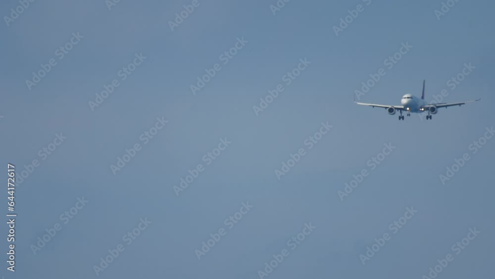 Passenger aircraft approaching landing. Jet plane flies, long shot. Front view, plane descending Passenger aircraft approaching landing. Jet plane flies, long shot. Front view, plane descending
