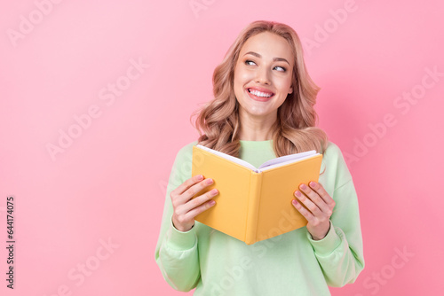 Photo of pretty creative minded lady toothy smile hold book look empty space isolated on pink color background