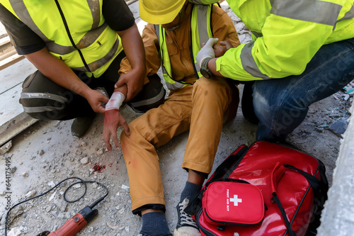 Fotografía First aid team support to builder worker after hand injury bleeding, accident at work, Using construction power tools unsafe and negligence at the construction site
