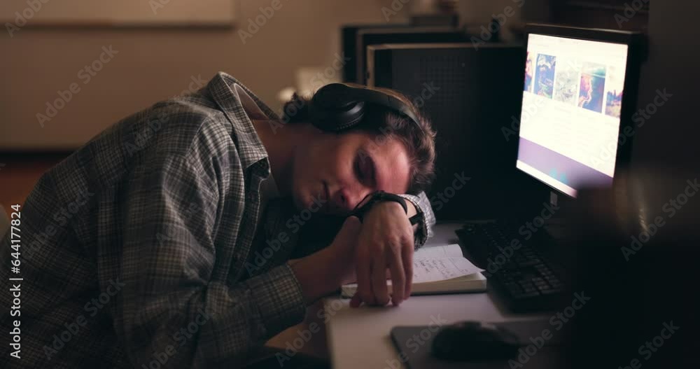 Desk, sleeping student and man on headphones, tired or stress at night on computer. Fatigue, bored or person rest on table, burnout and exhausted in learning, education or study in university college Desk, sleeping student and man on headphones, tired or stress at night on computer. Fatigue, bored or person rest on table, burnout and exhausted in learning, education or study in university college