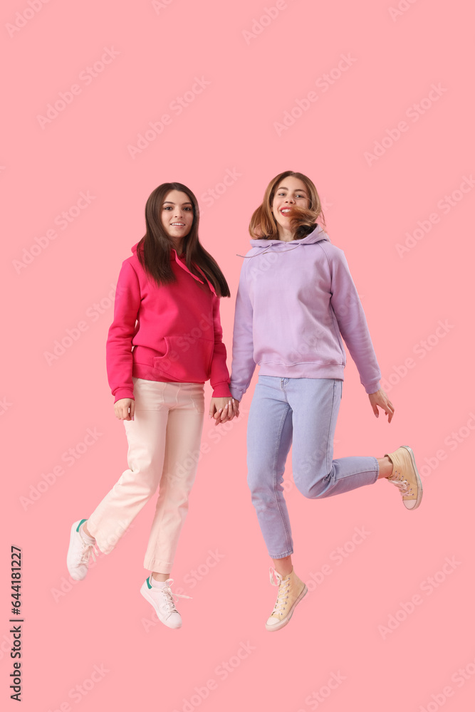 Obraz premium Female friends jumping on pink background