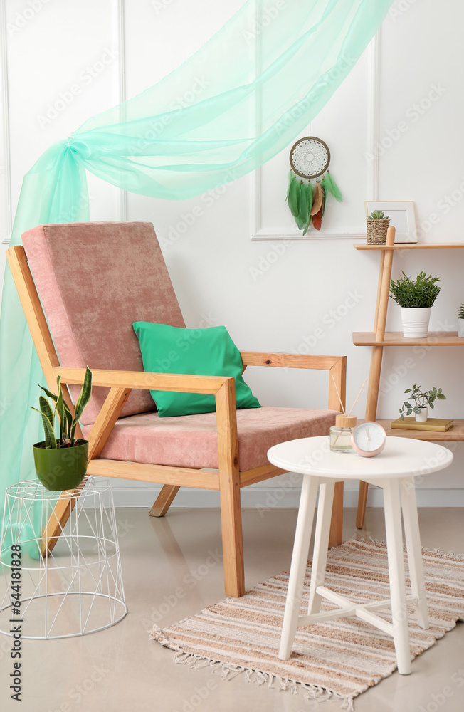 Interior of stylish room with armchair and dream catcher on wall Interior of stylish room with armchair and dream catcher on wall