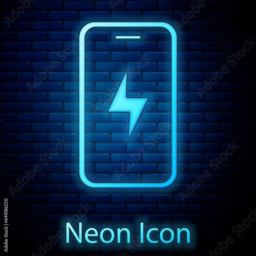 Glowing neon Smartphone charging battery icon isolated on brick wall background. Phone with a low battery charge. Vector