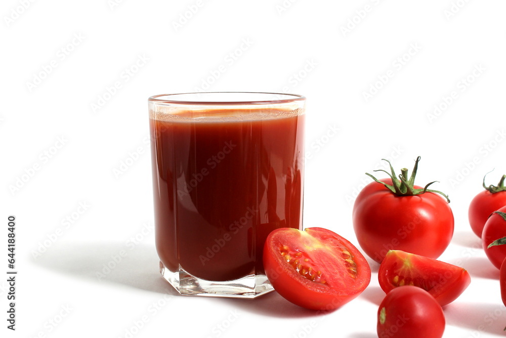 On a white background is a glass of tomato juice with tomatoes and herbs. On a white background is a glass of tomato juice with tomatoes and herbs.